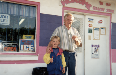 Sean as a child with his dad outside their family store